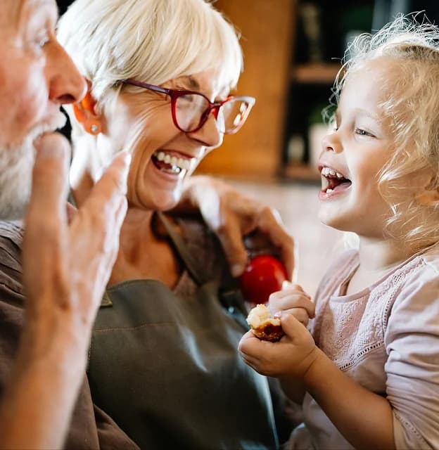 Grandparents laughing with their grandchild