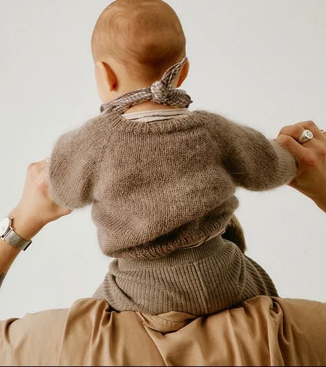 A child riding on a parent’s shoulders